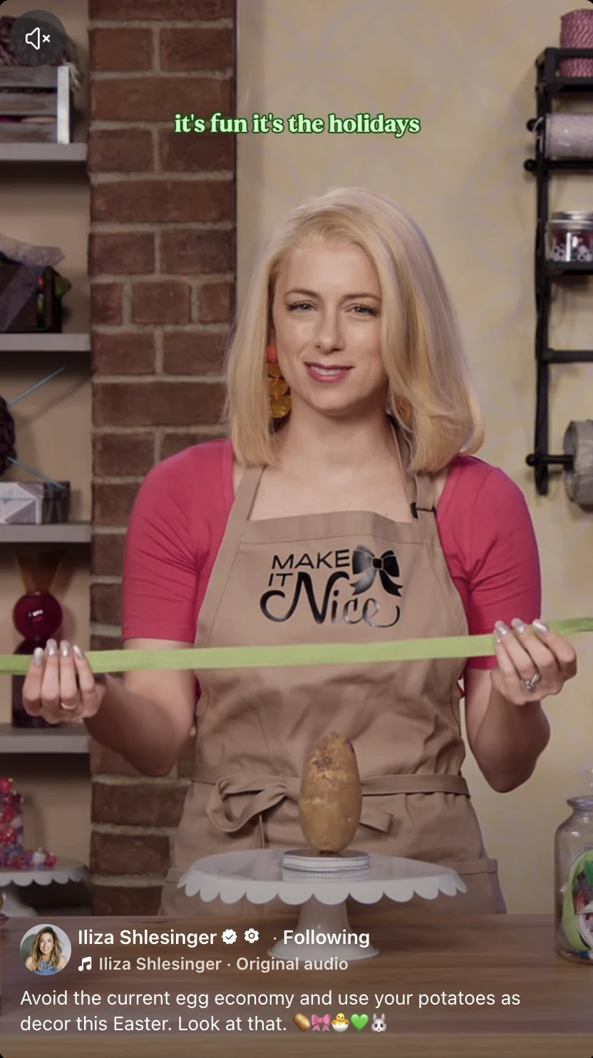 Iliza Shlesinger holding a green paper strip above a potato in a reel about using potatoes as Easter decorations.