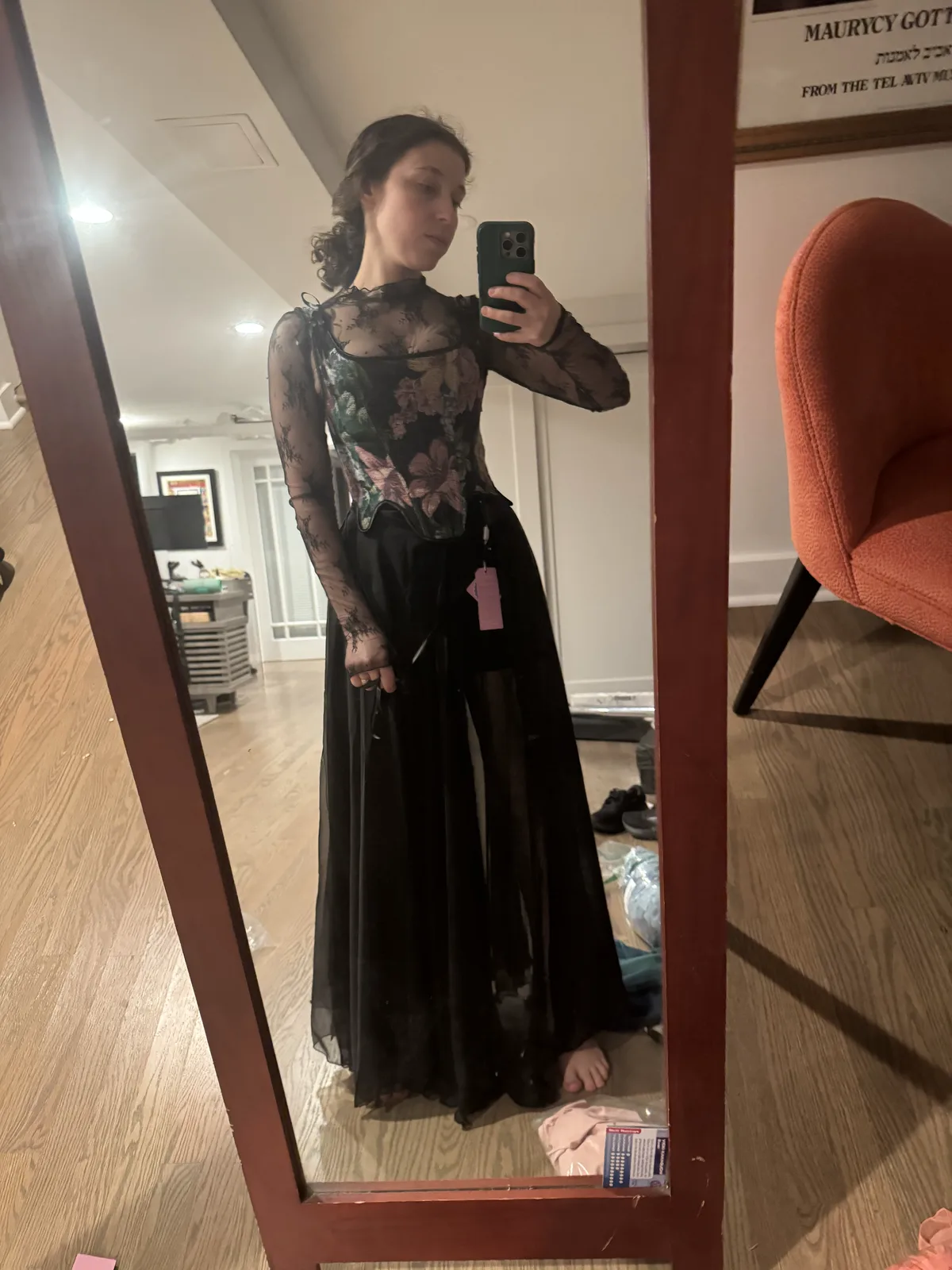 Mirror selfie wearing a floral black corset with a long black tulle skirt.