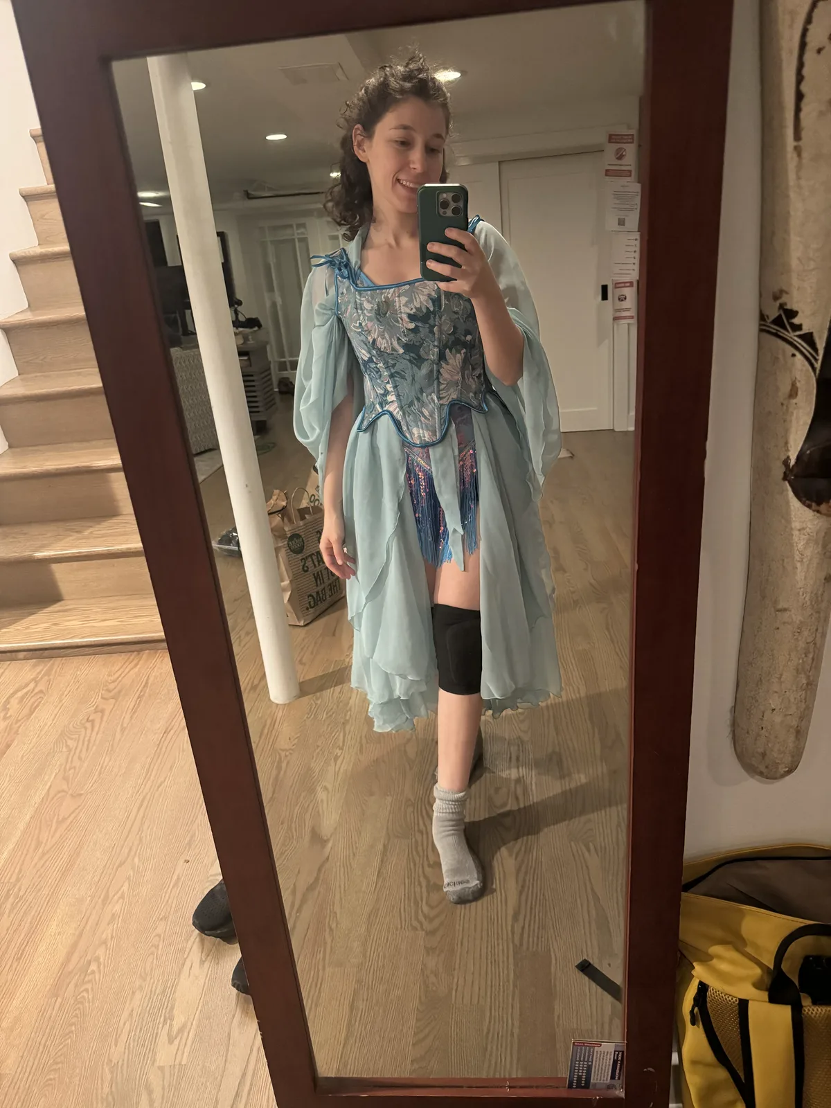 Full-length mirror selfie wearing a short layered light blue outfit with a sheer wrap.
