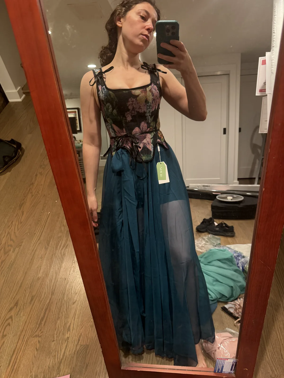 Mirror selfie wearing a floral black corset with a full dark teal skirt.